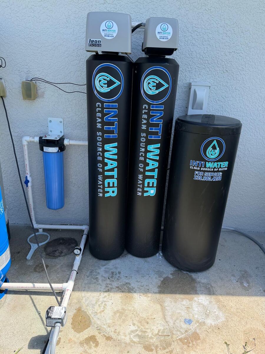 Two Inti Water treatment tanks beside a blue pressure tank