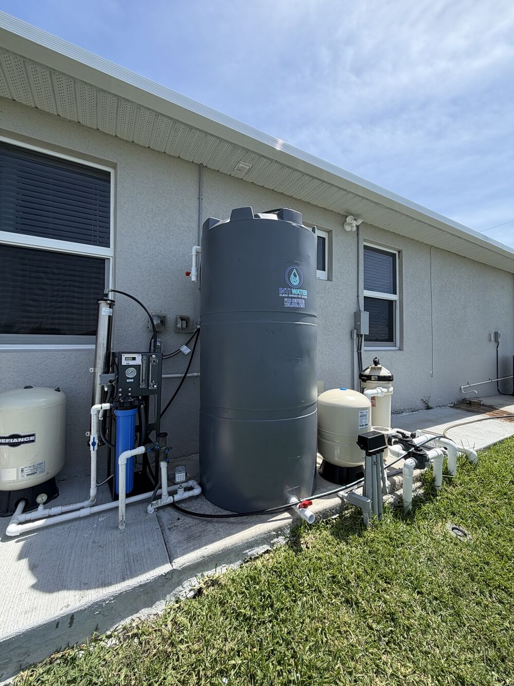 Well water treatment system with storage tank installed outside a Florida home